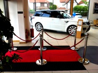 Fencing the passage of the car showroom with barriers and a red carpet
