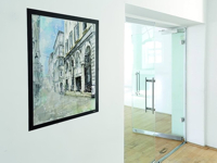 Office space with an art picture in a magnetic frame by the glass door