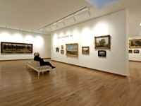 An art gallery with paintings hung on the CLICK RAIL frame system