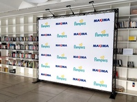 Baltame fone firminiai logotipai, šalia knygų lentynos, foto siena reklamai